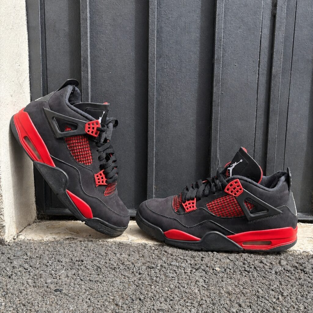 Paire de Jordan 4 Retro Red Thunder noire et rouge édition lifestyle